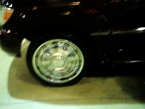 1998 Ford Taurus - A close-up of a black car's wheel and fender, showing a chrome rim.