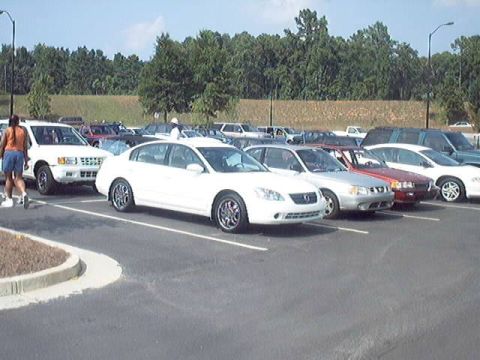 1998 Ford Taurus - A parking lot scene with multiple vehicles and a person walking.