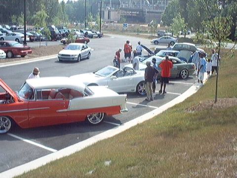 1998 Ford Taurus - A classic 1955 Chevrolet Bel Air is displayed at a car show with other vehicles.