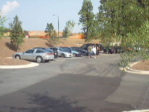 1998 Ford Taurus - A gathering of vehicles in a parking lot on a sunny day.