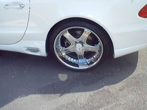 1998 Ford Taurus - A white car is shown from the side, highlighting its chrome wheels and body details.