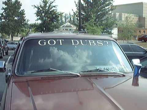 1998 Ford Taurus - This pickup truck features a prominent "GOT DUBS?" decal on its windshield, with other vehicles parked nearby.