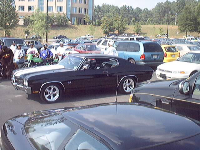 Black Chevelle SS coupe with white stripes and polished wheels in a parking lot