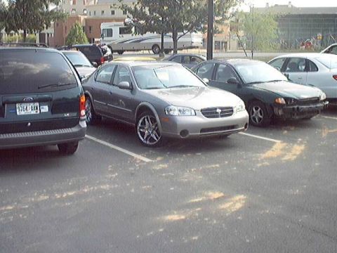 1998 Ford Taurus - A silver sedan is parked in a lot next to other vehicles, showing its front quarter.
