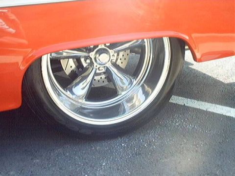 1998 Ford Taurus - Custom chrome wheel and drilled brake rotor detail on an orange car.