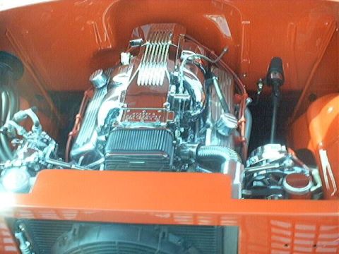 1998 Ford Taurus - Close-up of a custom V8 engine bay, polished chrome components and vibrant orange paintwork.