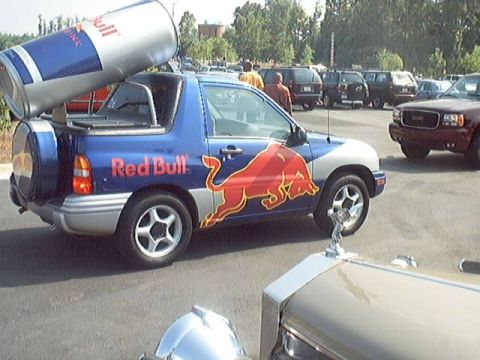 1998 Ford Taurus - Suzuki Vitara convertible modified with Red Bull branding and a large can on its roof.
