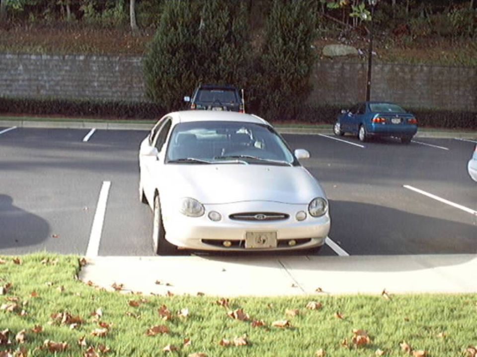 Silver Ford Taurus sedan parked in a lot, seen from the front