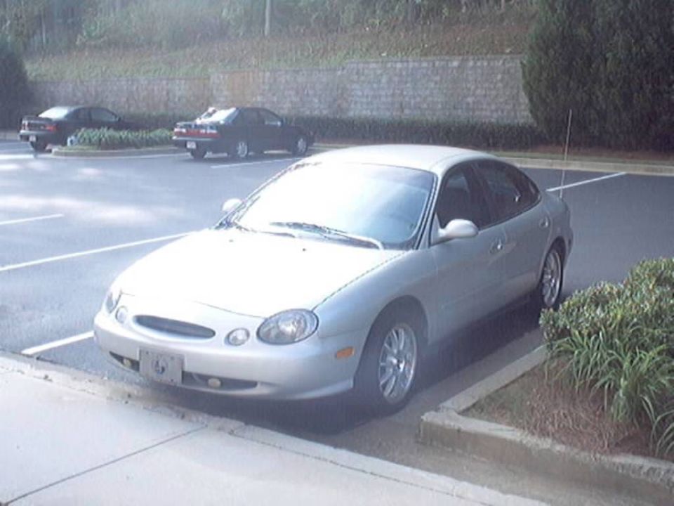 Silver 1990s Ford Taurus sedan, front three-quarter view in a parking lot