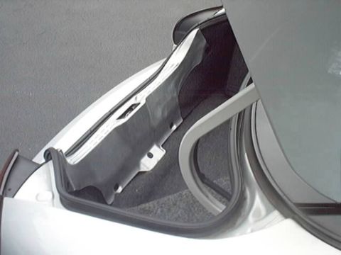 1998 Ford Taurus - Close-up of an open trunk/rear hatch area on a silver vehicle, showing the black rubber weatherstrip seal, painted body channel, and gray i…