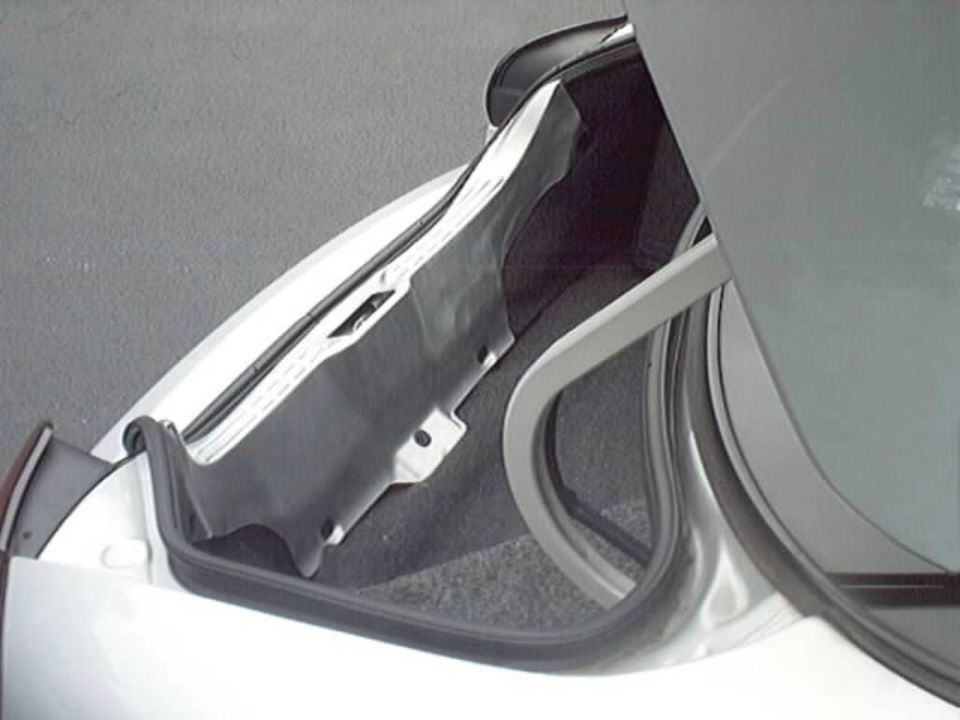 Open trunk corner of silver car showing black rubber seal and body channel