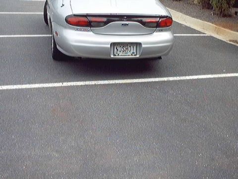 1998 Ford Taurus - Rear view of a silver 1990s Ford Taurus parked in a lot, showing its rounded oval-era styling and taillights. It wears a Georgia license pl…