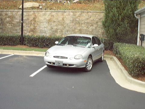 1998 Ford Taurus - Silver 1998 Ford Taurus parked in a lot.