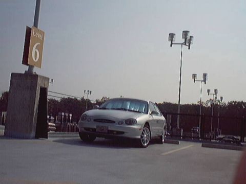 1998 Ford Taurus - Silver 1998 Ford Taurus parked in a lot with a level 6 sign visible.