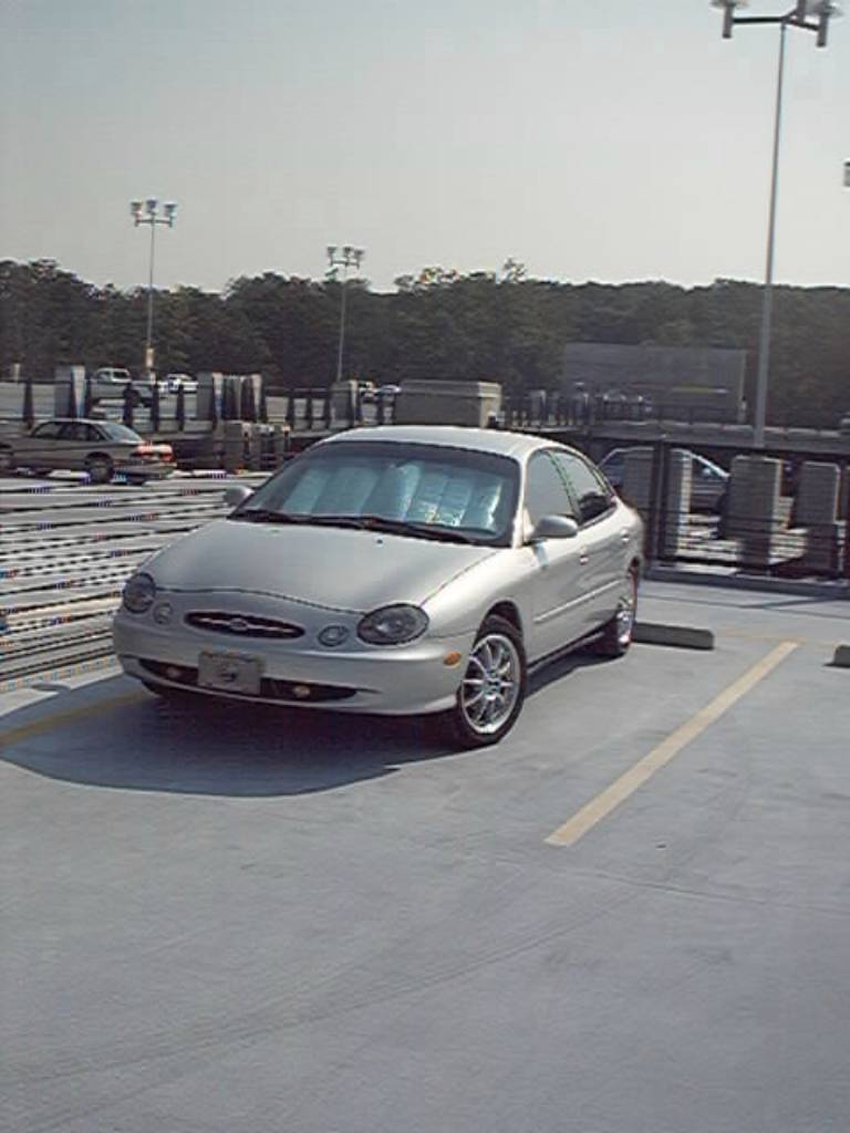 Silver sedan parked in a lot. Looks like a 2000 model