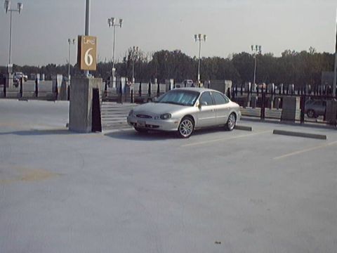 1998 Ford Taurus - A silver 1998 Ford Taurus is parked on level 6 of a parking garage.