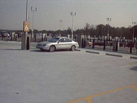 1998 Ford Taurus - A silver 1998 Ford Taurus is parked in a lot, seen from the front three-quarter angle.