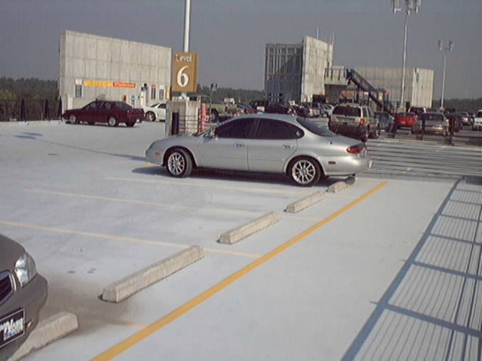 1998 Ford Taurus parked in a multi-level parking garage, side view