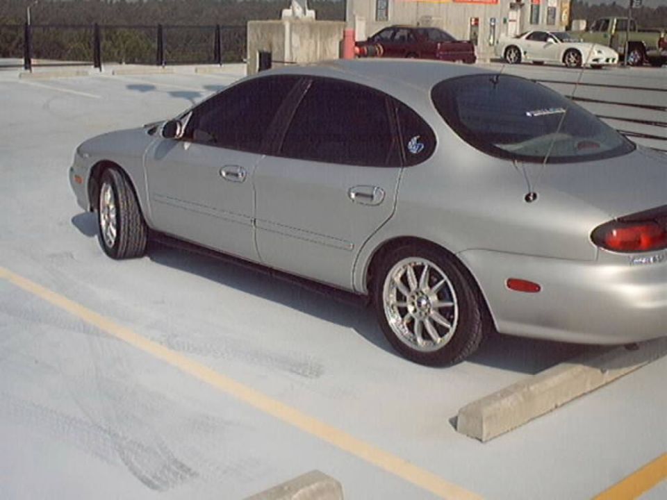 Silver Mercury Sable sedan parked on a rooftop parking deck
