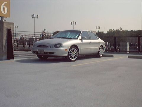 1998 Ford Taurus - A silver 1998 Ford Taurus sedan is parked in an outdoor lot.