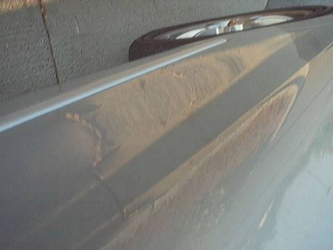 1998 Ford Taurus - The paint is peeling off the car door, revealing rust underneath.