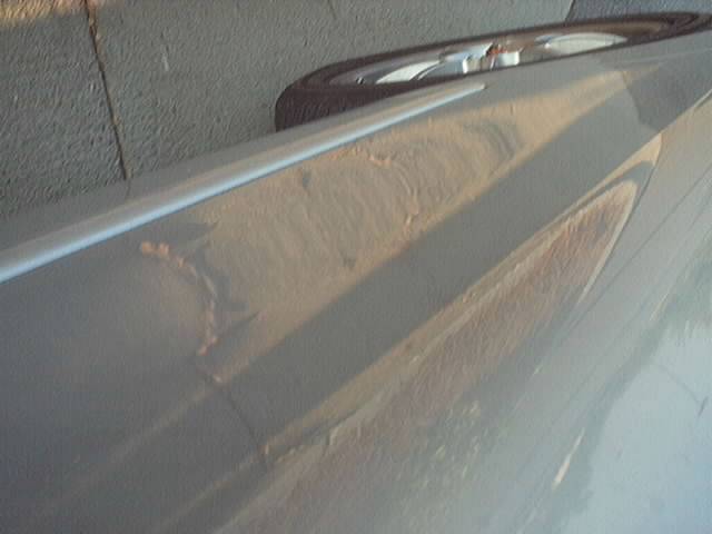 close-up of peeling paint and rust on a car door