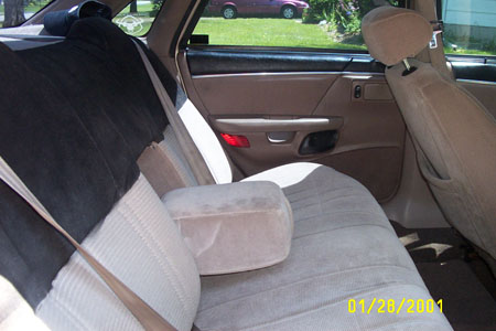 1993 Ford Taurus - Interior view of a car's back seat and door panel, with a second vehicle visible through the window.