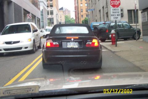 1993 Ford Taurus - A black convertible is seen from behind in traffic, displaying the license plate EPE-1828.
