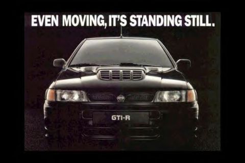 1993 Ford Taurus - Scanned magazine advertisement showing a head-on view of a black Nissan hatchback with a large hood scoop, twin-slot grille and a plate rea…