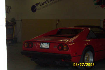 1993 Ford Taurus - Rear view of a red sports car with license plate NCF-1882, seen indoors.