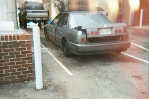 1991 Ford Taurus - This gray sedan, possibly a 1991 Ford Taurus, is seen from the rear with custom taillights and a Maryland license plate.