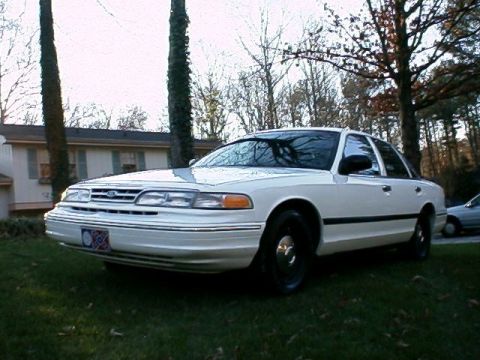 1996 Ford Crown Victoria - A white 1995 Ford Crown Victoria is parked on a grassy lawn in front of a house.