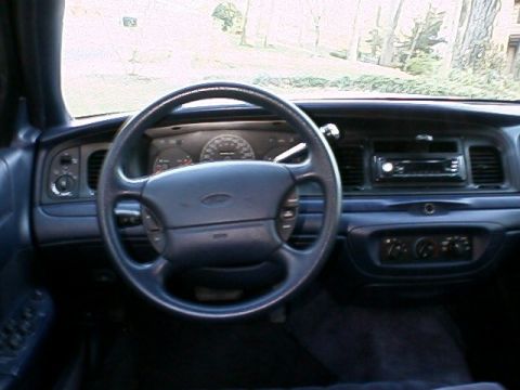 1996 Ford Crown Victoria - The dashboard and steering wheel of a 1996 Ford Crown Victoria are visible in this interior shot.