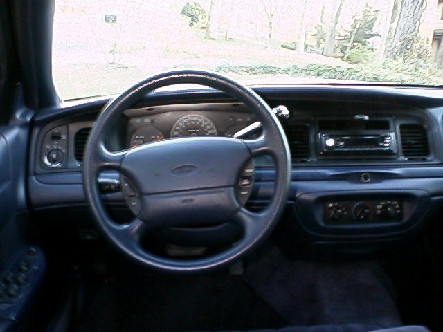 Blue Ford sedan interior dashboard with steering wheel and gauges
