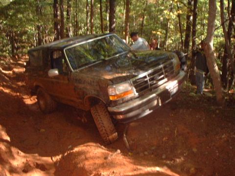 1990 Ford Bronco - This Ford Bronco navigates a challenging off-road course through a wooded area.