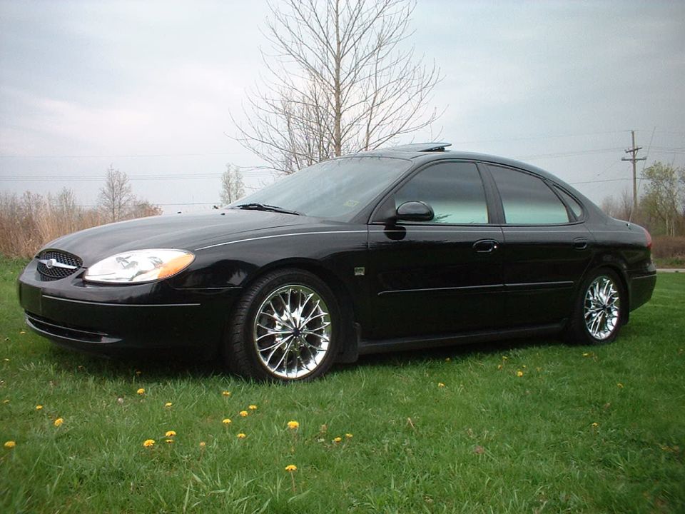 Black 2000 Ford Taurus sedan parked on grass