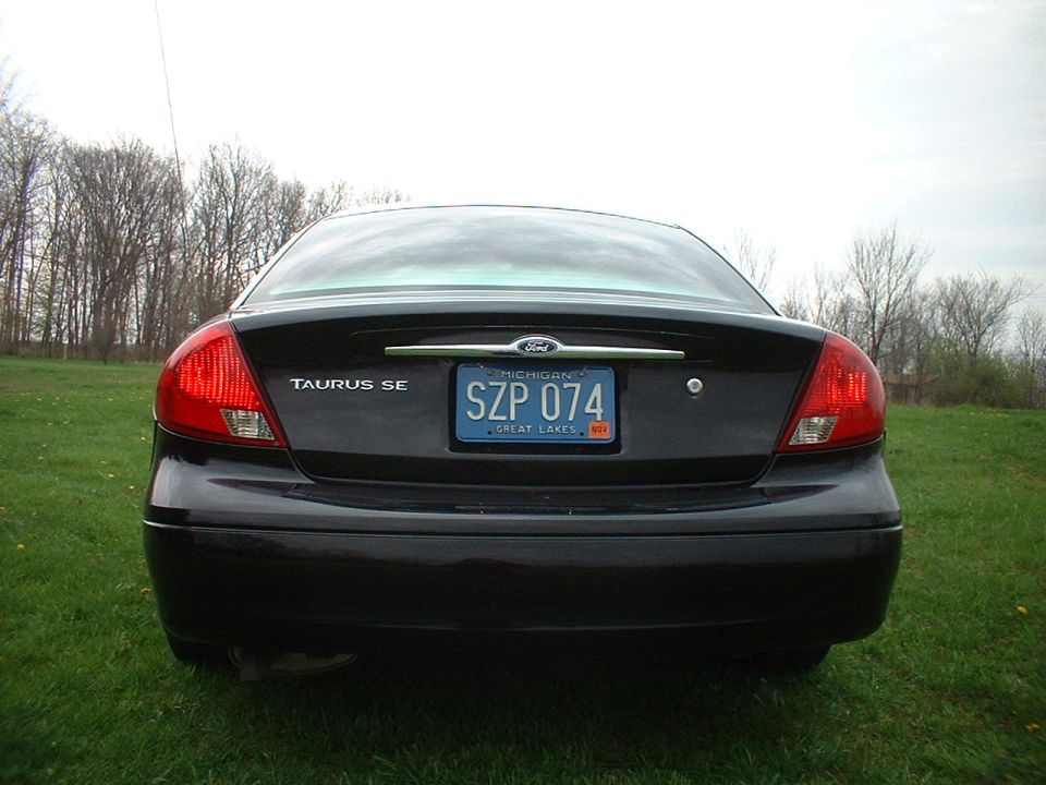 Rear view of a black Ford Taurus SE with Michigan license plate SZP 074