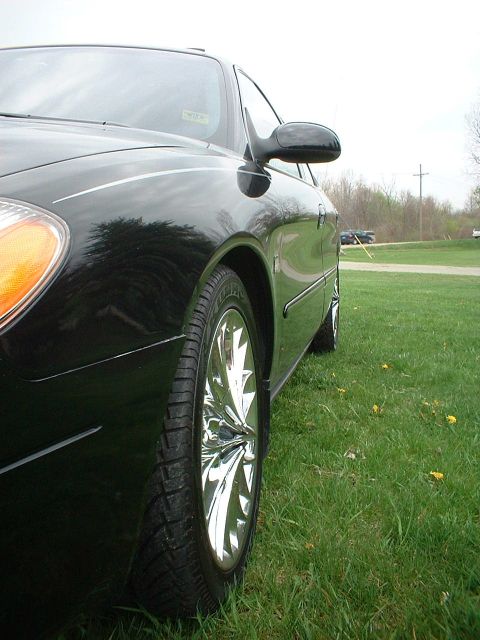 2000 Ford Taurus - A black 2000 Ford Taurus is shown from the side, shiny chrome wheels and a clean exterior.
