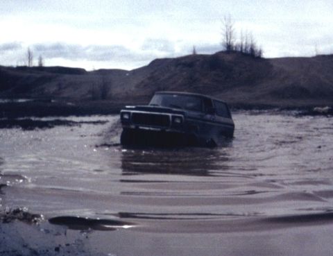 1978 Ford Bronco - This 1978 Ford Bronco navigates through a muddy, watery terrain under an overcast sky.