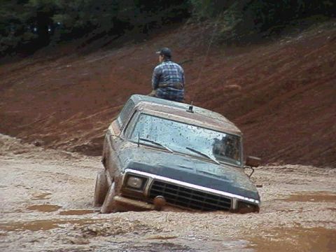 1978 Ford Bronco - A person sits atop a 1978 Ford Bronco as the vehicle becomes stuck in thick mud.