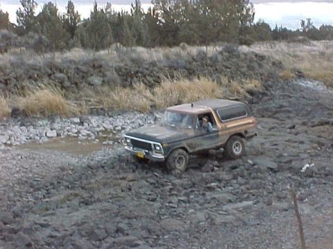 1978 Ford Bronco - 1978 Ford Bronco navigates a rocky, muddy off-road path.
