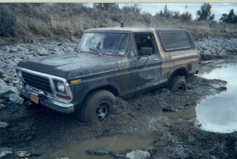 1978 Ford Bronco - A muddy 1978 Ford Bronco is stuck in a muddy, watery terrain.