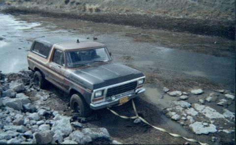 1978 Ford Bronco - This 1978 Ford Bronco is stuck in a muddy, rocky area, with a tow strap attached to the front bumper.