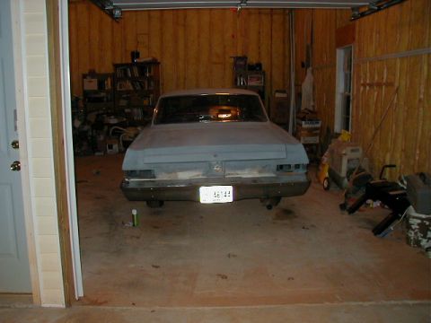 1965 Mercury Comet - Rear view of a 1965 Mercury Comet, appearing to be in primer and undergoing restoration in a garage.