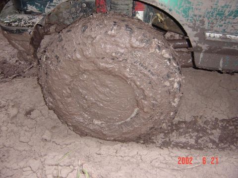 1996 Ford Bronco - This vehicle is deeply stuck in mud, with the tire completely covered.