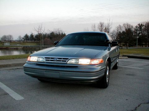 1995 Ford Crown Victoria - A 1995 Ford Crown Victoria is parked outside on a cloudy day.