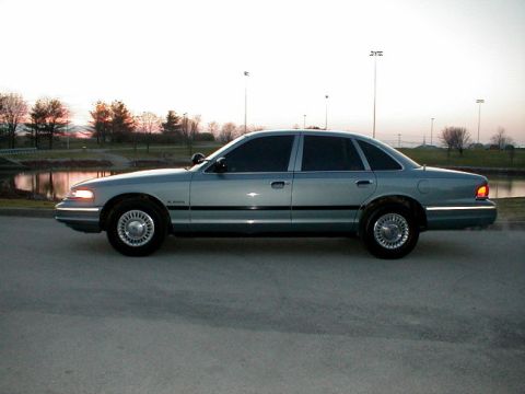 1995 Ford Crown Victoria - A 1995 Ford Crown Victoria Police Interceptor is seen from the side with a lake and trees in the background.