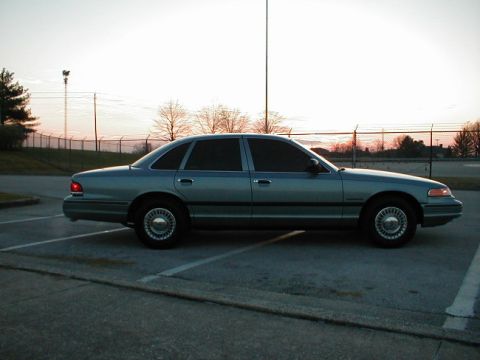 1995 Ford Crown Victoria - Side profile of a 1995 Ford Crown Victoria sedan parked in a lot during sunset.