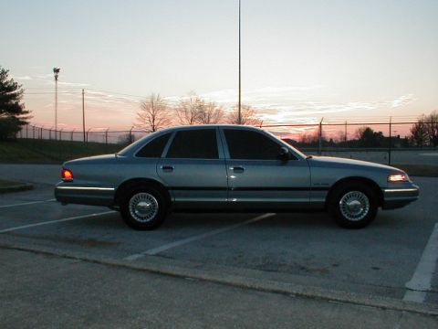 1995 Ford Crown Victoria - A blue 1995 Ford Crown Victoria is parked in a lot as the sun sets.