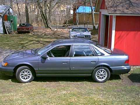 1993 Ford Taurus - Gray 1992 Ford Taurus sedan parked in a yard with other vehicles visible.